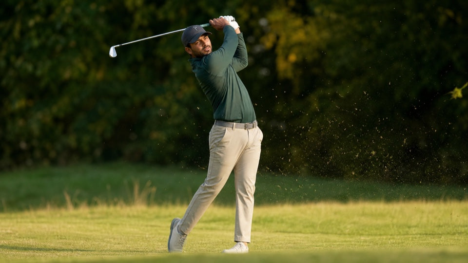 Golfer finishing a shot while wearing the EnduraLite hat