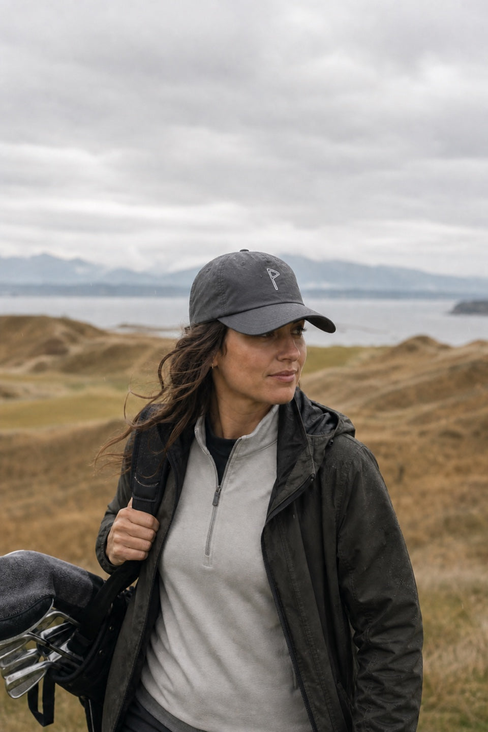Woman golfer wearing the EnduraLite hat in changing coastal conditions